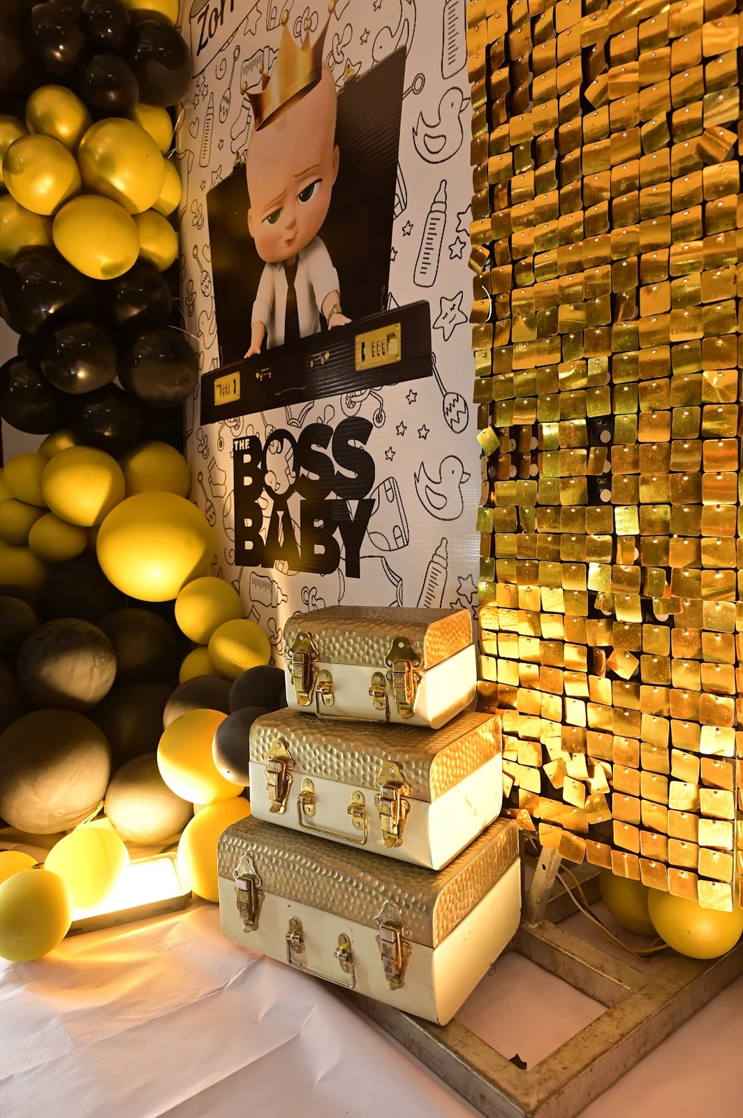 Black and gold Boss Baby birthday decorations with stacked gift cases